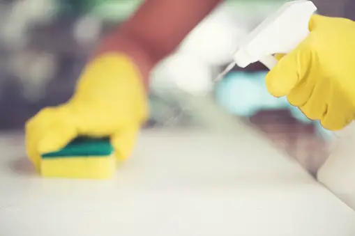 Cleaning surface with cleaning product while wearing gloves