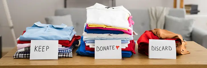 Clothes sorted into 3 piles: keep, donate, discard