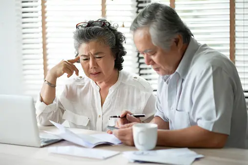 Senior couple sitting in front of computer paying bills