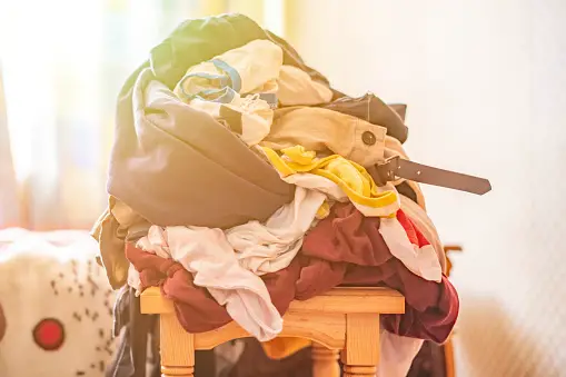 Dirty clothes piled up on a chair in the bedroom 