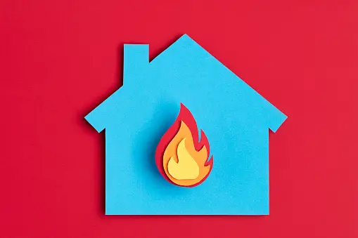 Fire icon displayed in the center of a paper cut out of a house