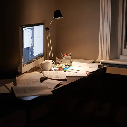 Messy desk in dimly lit bedroom