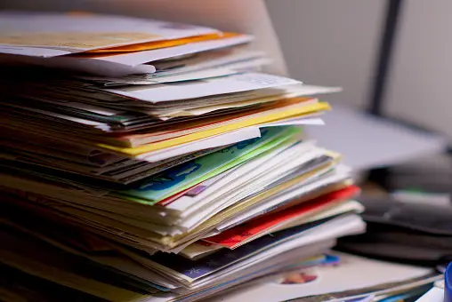 Stack of paper, files, photos on a desk
