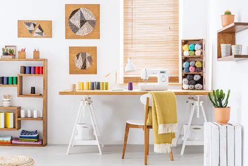 Craft room with sewing machine and knitting arranged neatly 