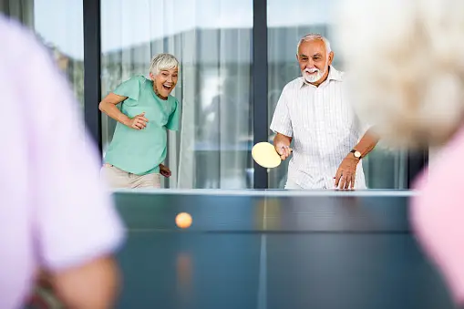 Older couples playing ping pong
